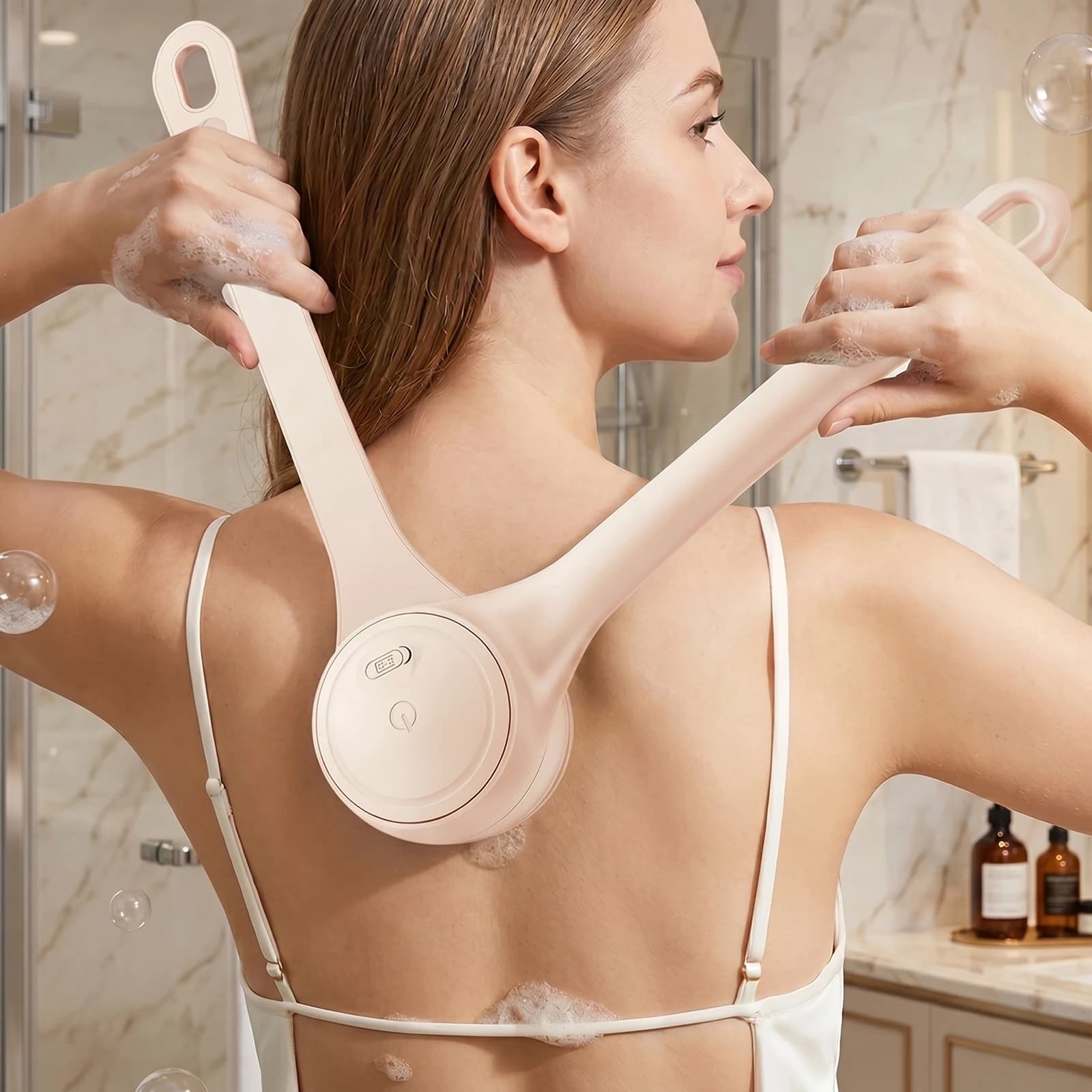 Brosse de bain à manche long incurvé suspendue par son anneau dans une douche