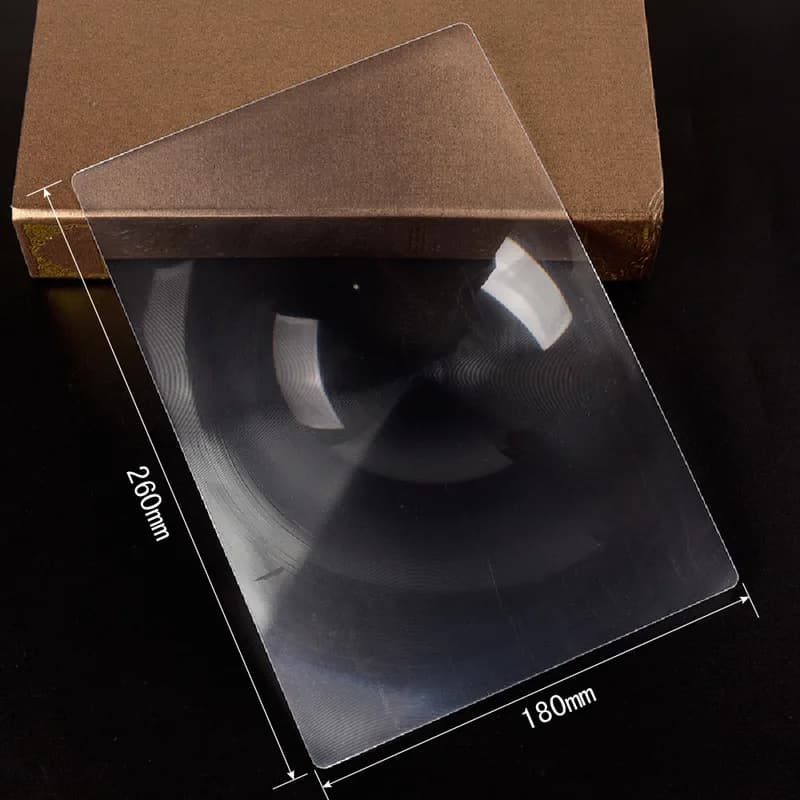 Loupe rectangulaire pleine page posée à plat sur un livre ouvert, cadre rigide visible